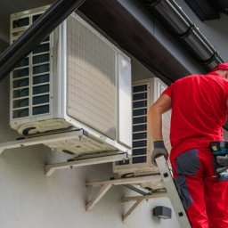 Caucasian Heating and Cooling Technician Performing Scheduled Heat Pump and Air Condition Units Maintenance