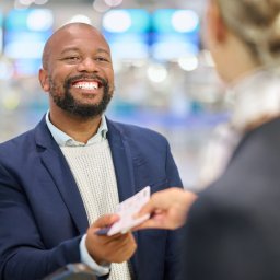 African businessman, ticket and woman at airport with excited smile, customer support and help for .